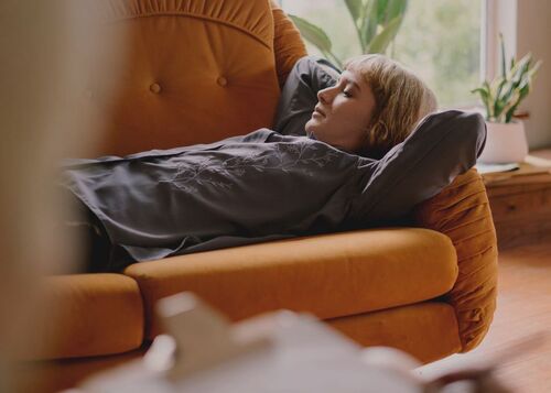 Frau liegt auf Sofa und entspannt